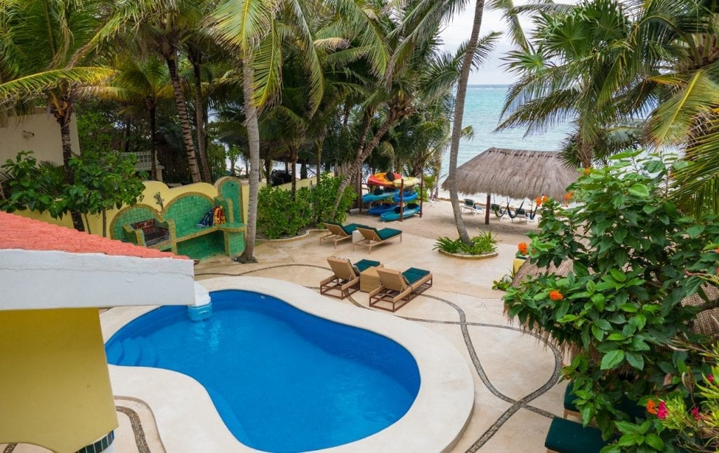 Villa Iguana garden pool and loungers viewed from an upper terrace — Tulum, Mexico