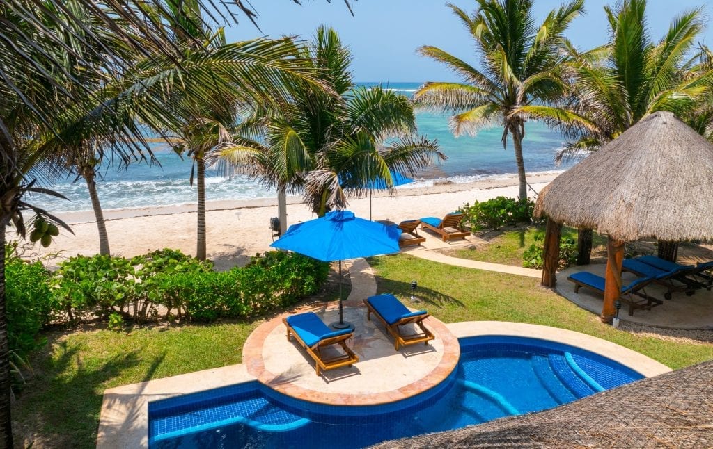 Casa Magica curved pool with two loungers on a central island by the beach — Akumal, Mexico