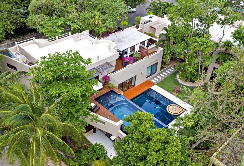 Quinta Clara aerial view of the villa rooftops and pool among palms — Playa del Carmen, Mexico