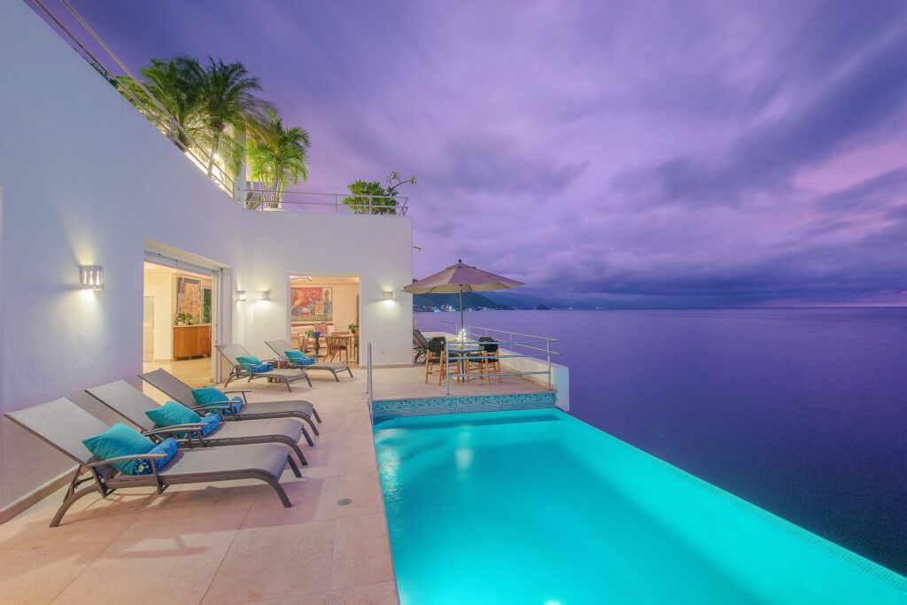 Villa Balboa the long pool electric under the storm dusk — Puerto Vallarta, Mexico