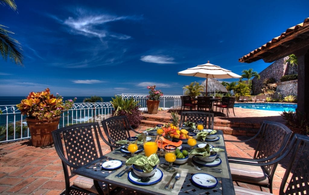 Villa Celeste terrace table with fruit and juice beside the pool and ocean — Puerto Vallarta, Mexico