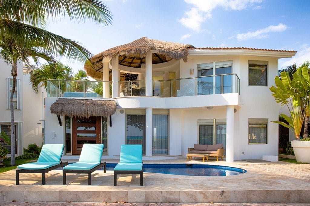 Villa Turquesa Playa two-story facade with thatched terrace roof and small pool — Playa del Carmen, Mexico