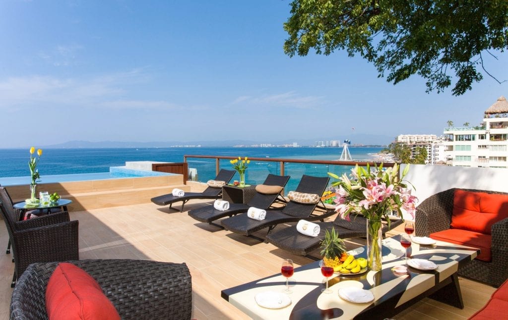 Vallarta Shores Penthouse 4 Bedrooms terrace loungers and red seating with floral table — Puerto Vallarta, Mexico