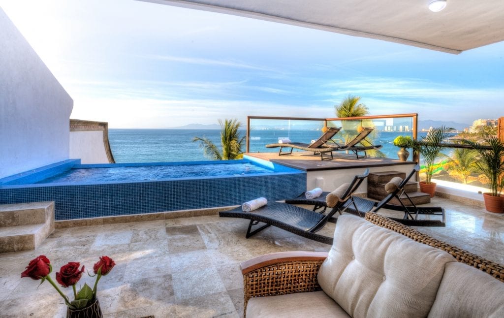 Vallarta Shores Sky Suite D terrace pool with a cushioned woven sofa and ocean view — Puerto Vallarta, Mexico