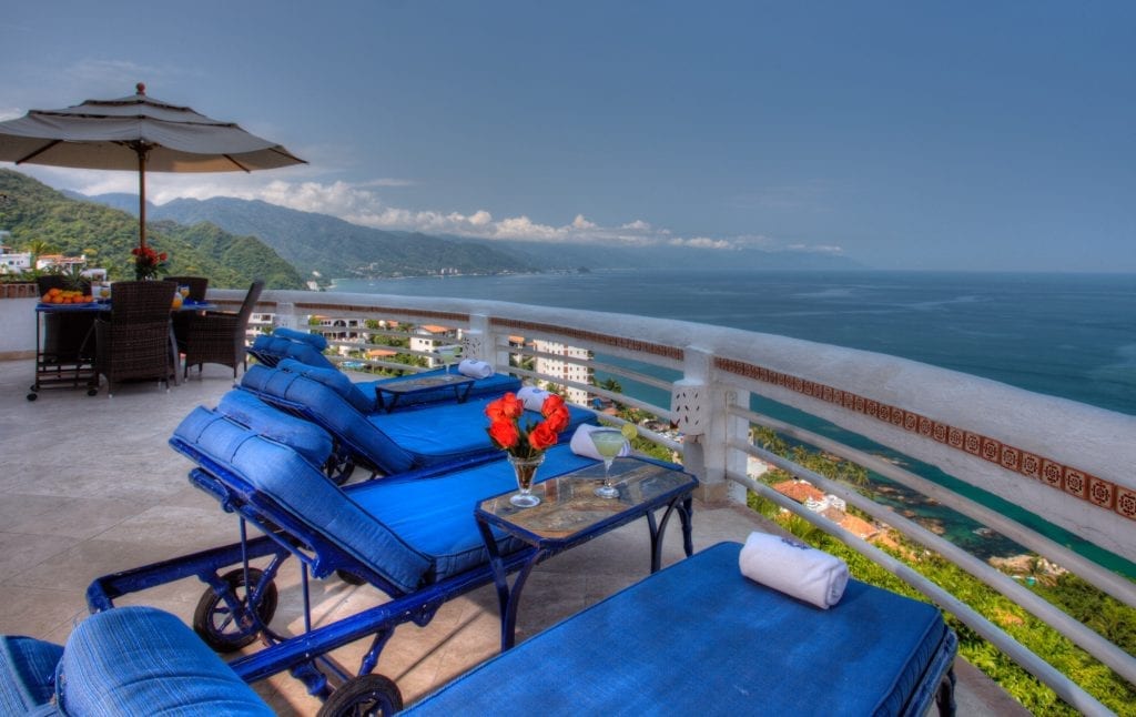 Villa Azul Conchas Chinas blue terrace loungers under an orange umbrella by the sea — Puerto Vallarta, Mexico