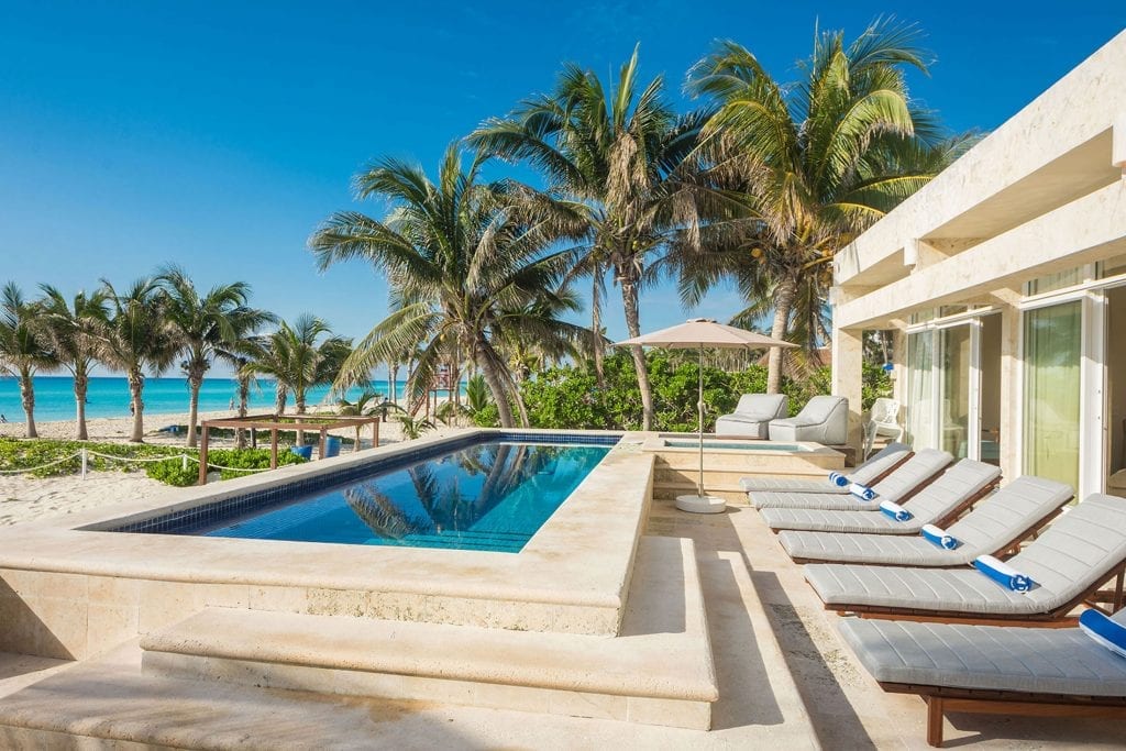 Beach House raised pool with a row of loungers above the beach — Playa del Carmen, Mexico