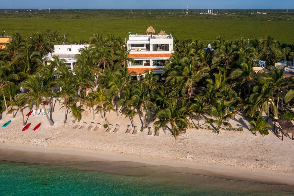 A white house behind the palms on the Soliman Bay shore, seen from the air