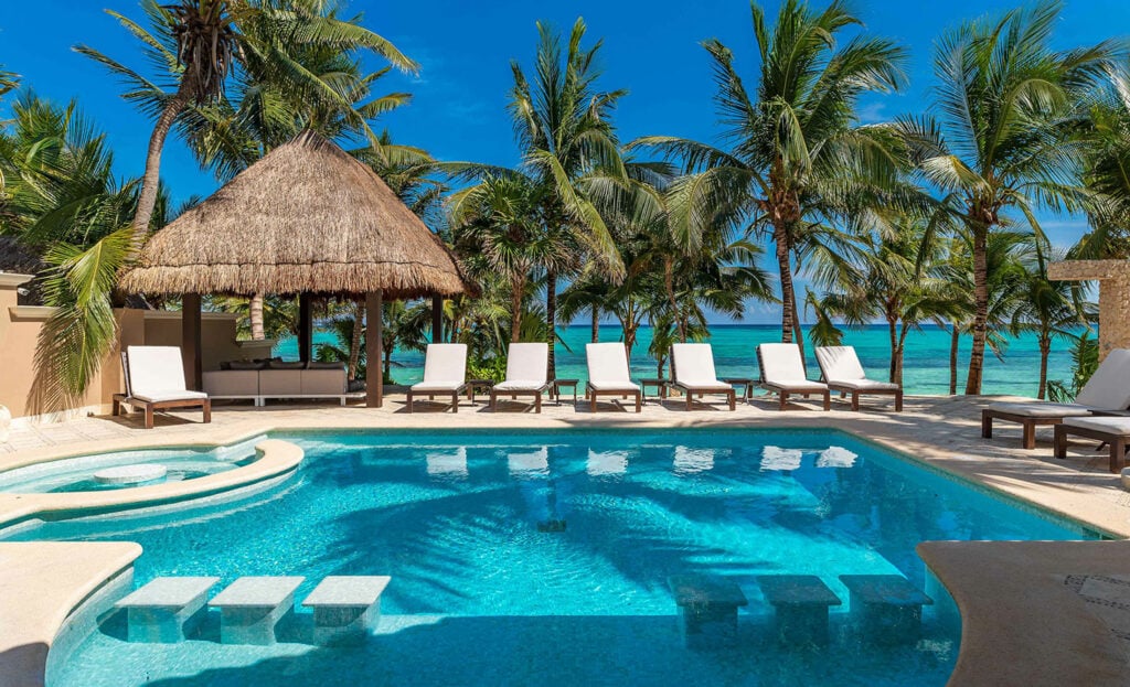 Villa Lol Beh Soliman pool with submerged steps, a palapa and ocean-facing loungers — Tulum, Mexico