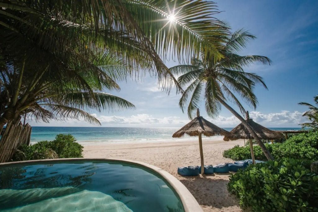 Casa Bonita small curved pool overlooking the beach and palms — Tulum, Mexico