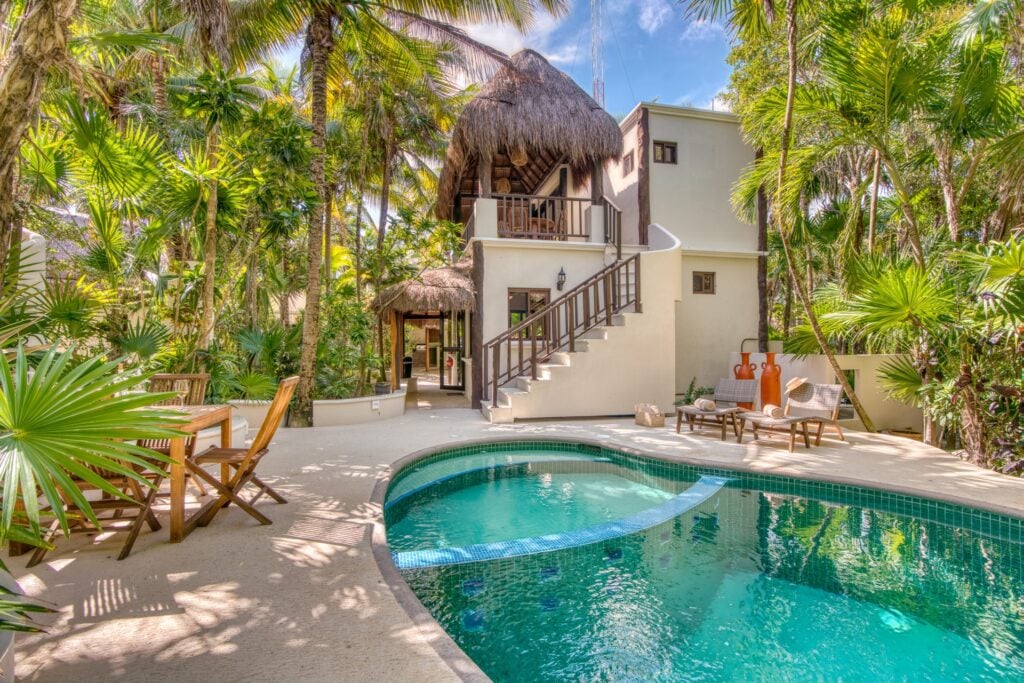 Casa Corazon Tres two-story bungalow exterior with palapa roof staircase and private pool — Soliman Bay Tulum