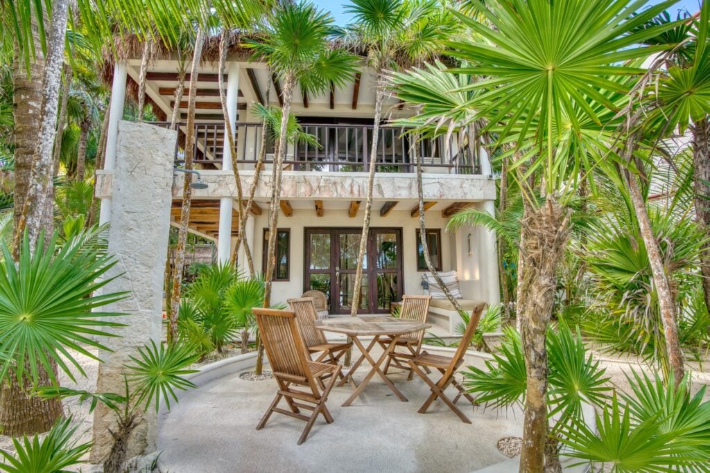 Casa Corazon Dos two-story casita facade with outdoor dining amid palms — Soliman Bay Tulum