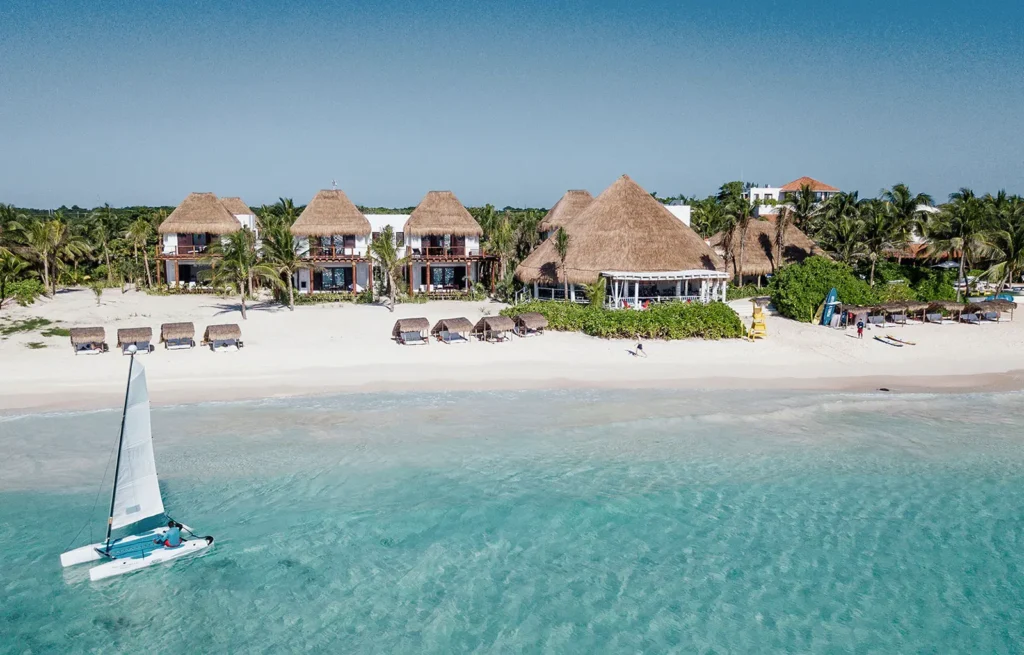 Villa Yuum Ha aerial view of beachfront buildings and a sailboat — Puerto Aventuras, Mexico