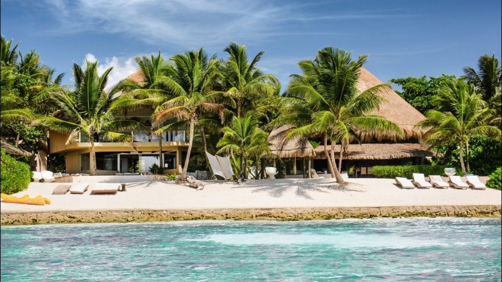 Casa Del Agua palm-lined beachfront seen from across the water — Puerto Aventuras, Mexico