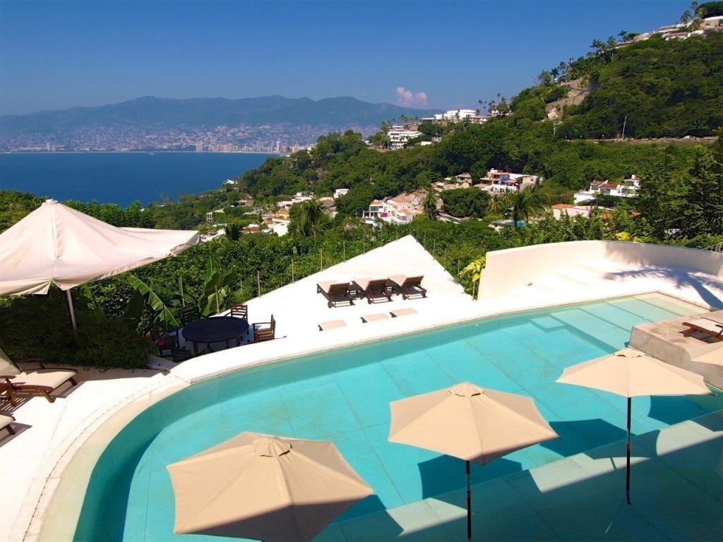 Casa Luna pool with umbrellas and loungers above the bay — Acapulco, Mexico