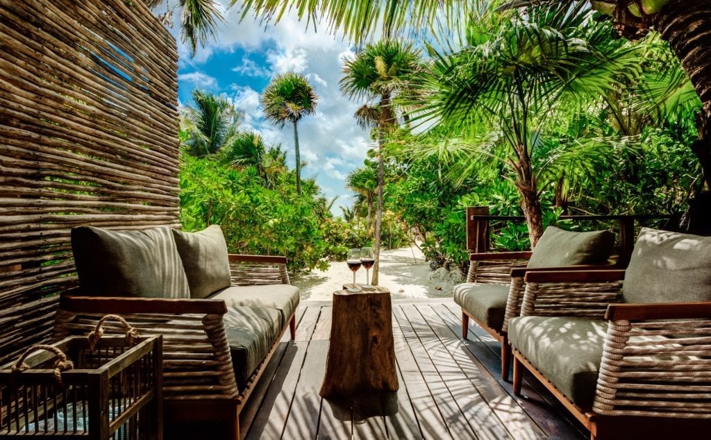 Casa Chechén deck chairs facing the palms and open sky — Tulum, Mexico