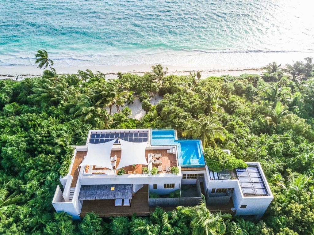 Casa Ikal aerial view of villa with rooftop pool and solar panels amid jungle near beach — Sian Kaan Tulum