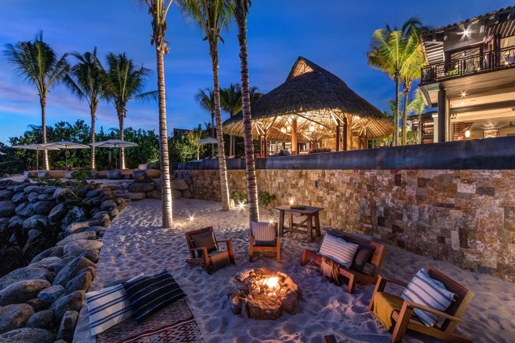 An image showing the fire pit at Casa Koko in Punta Mita, Mexico, surrounded by comfortable seating and set against the backdrop of the luxurious villa.