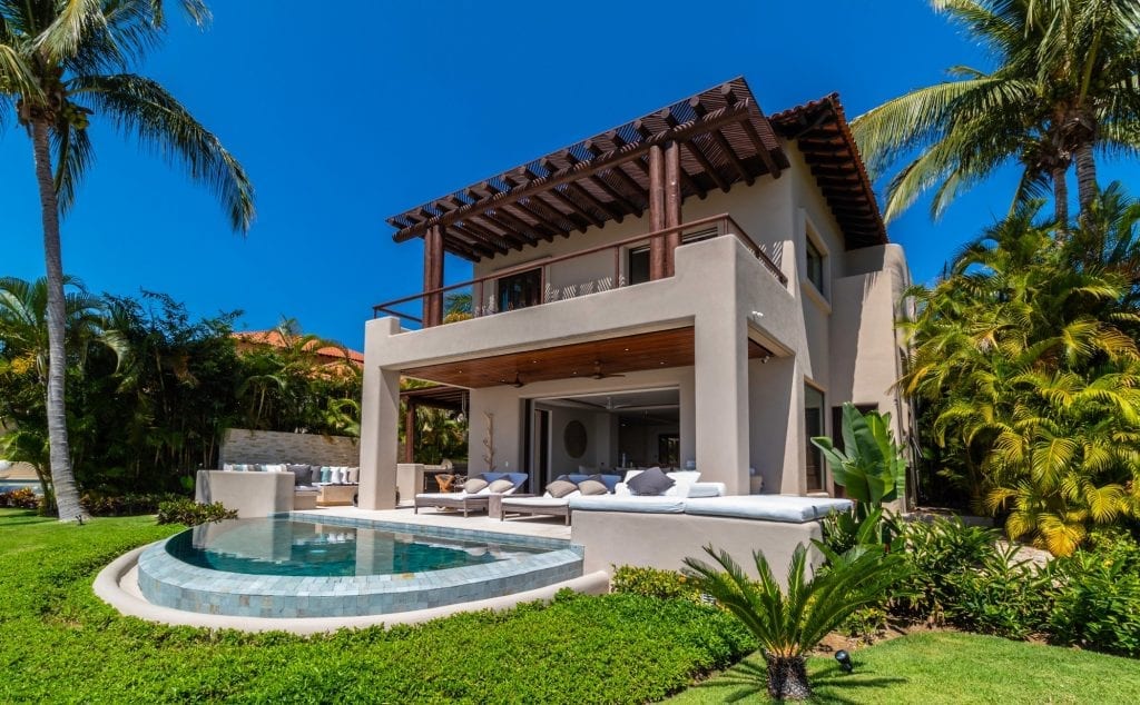 Casa Sole rear exterior with a curved pool and upper covered balcony — Punta Mita Nayarit, Mexico