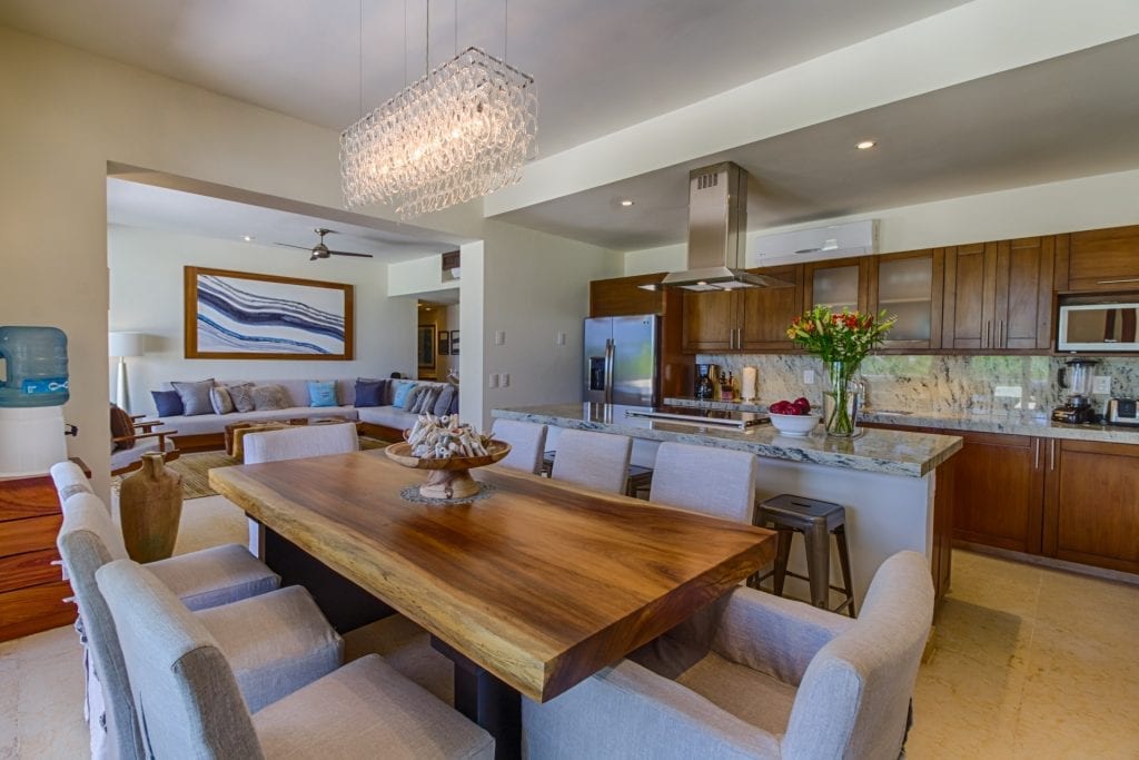 Condo Los Arboles dining table with the kitchen and salon beyond — Punta Mita, Mexico