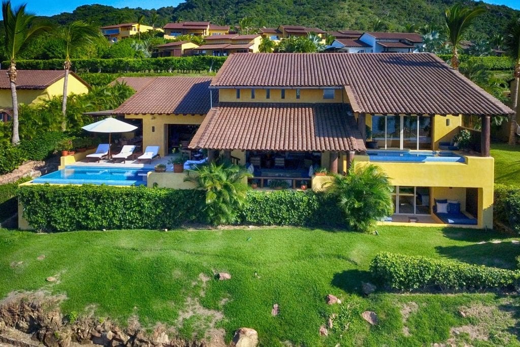 Four Seasons Twin Villas aerial view of the yellow residence, pool, and lawn — Punta Mita Nayarit, Mexico