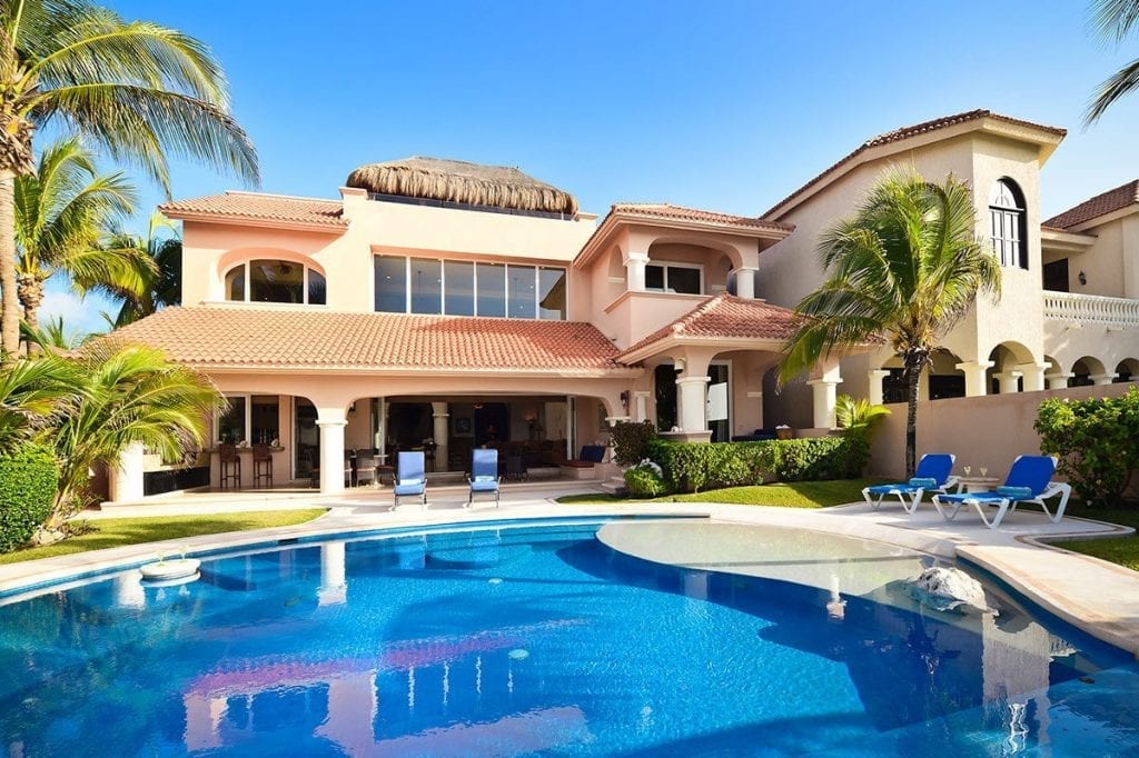 Villa Nautica exterior with pool and blue loungers — Puerto Aventuras, Mexico