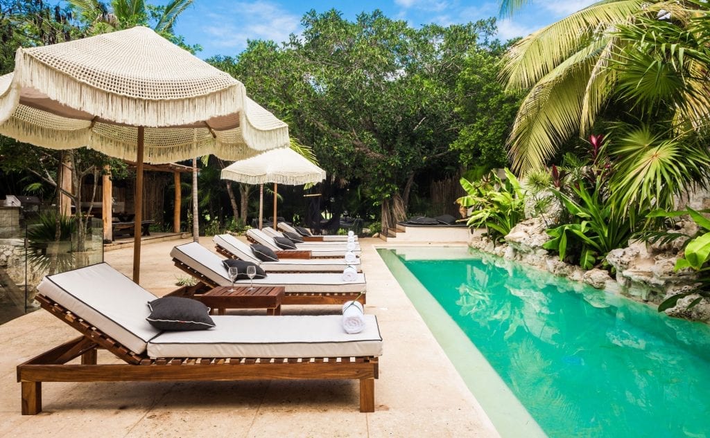 Casa Cenote row of sun loungers under fringed umbrellas by the pool — Puerto Aventuras, Mexico