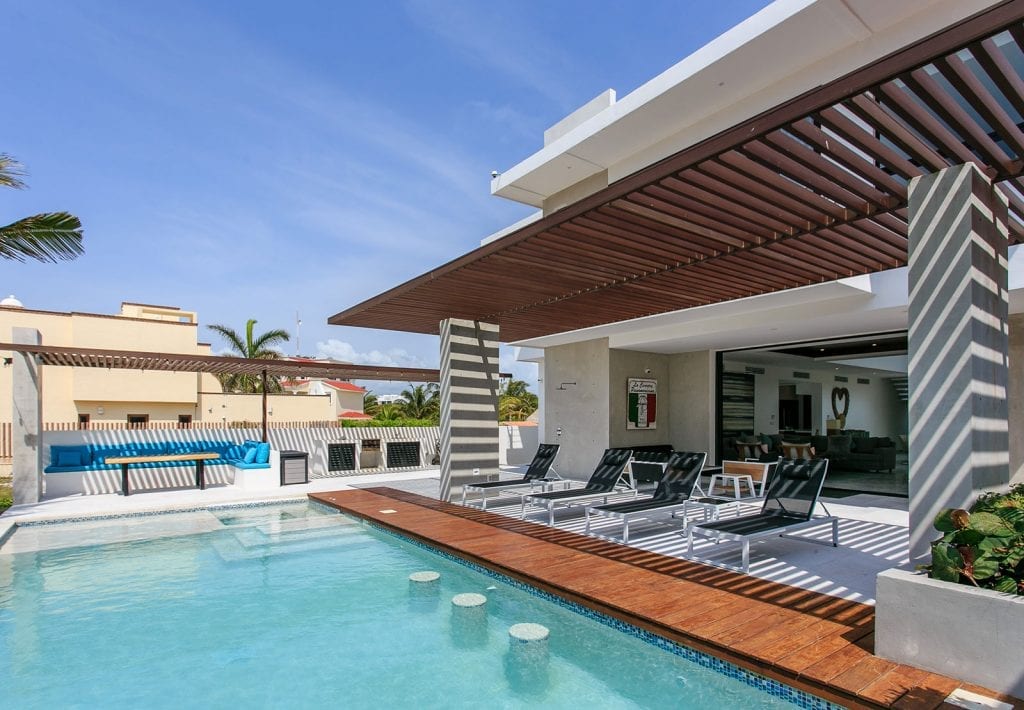 Villa Carrera loungers along the pool under the pergola — Playa del Carmen, Mexico