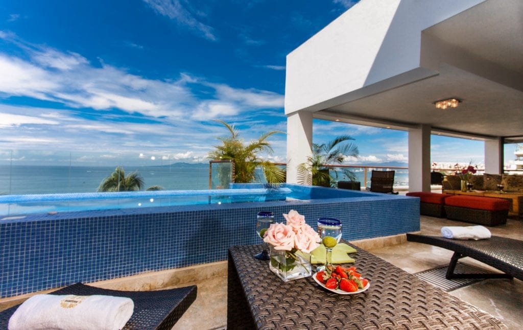 Vallarta Shores Sky Suite E terrace infinity pool with poolside table and ocean view — Puerto Vallarta, Mexico