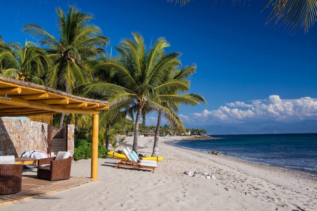 Villa Suenos del Alma beach pergola with loungers on the sand beneath palms — Punta Mita Nayarit, Mexico