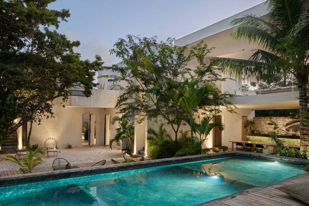 Chateau Sixteen pool and villa facade lit at dusk — Tulum, Mexico