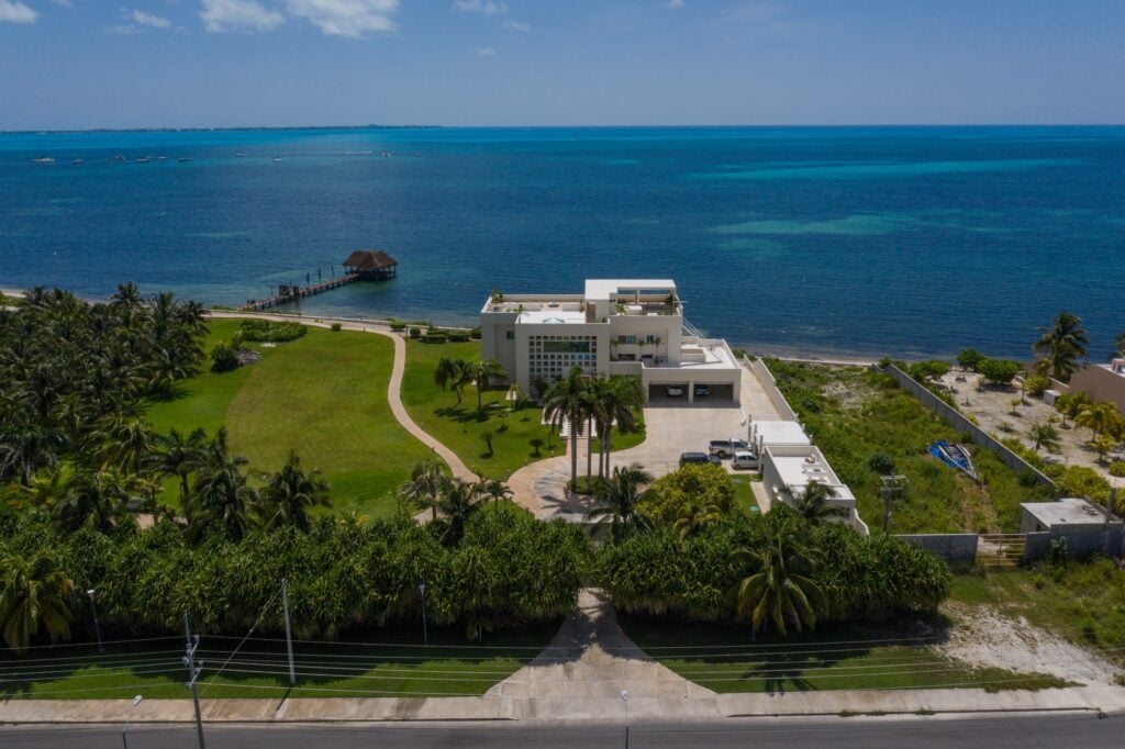 Villa Punta Sam aerial view with a long pier and waterfront lawn — Cancun, Mexico