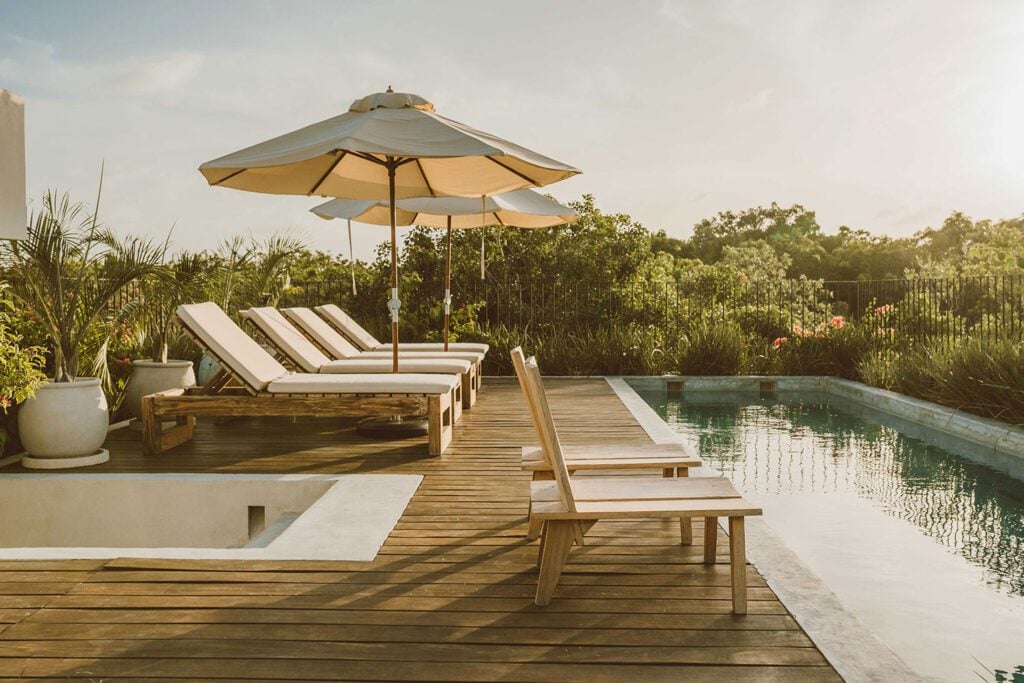 Villa Virginia rooftop pool deck with loungers, an umbrella and a rectangular pool — Tulum, Mexico