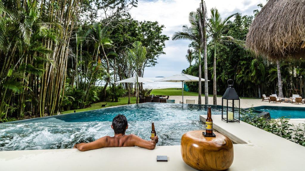 Cliente disfrutando de la piscina con vista al océano en una villa de Ranchos Estates Punta Mita