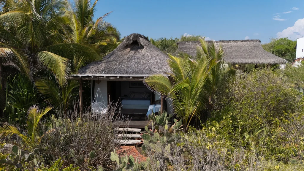 Casa Los Guajes steps rising to the white cottage in the scrub — Puerto Escondido, Mexico