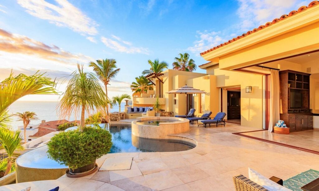 Casa Bella palms and loungers beside the pool and terrace doors — Los Cabos, Mexico