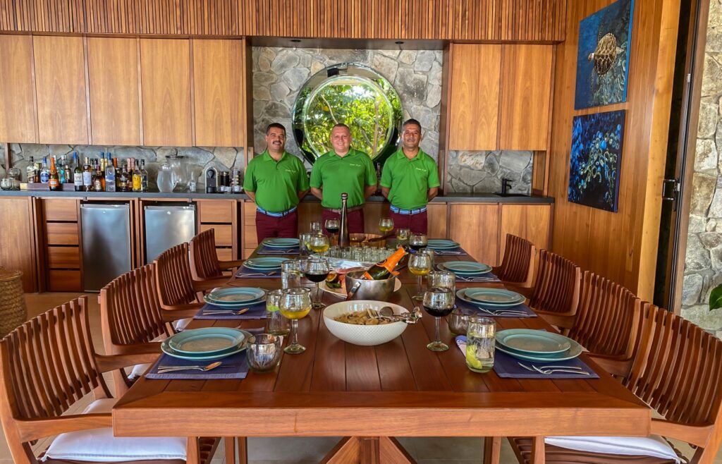 Professional villa staff standing at beautifully set dinner table in luxury villa in Puerto Vallarta