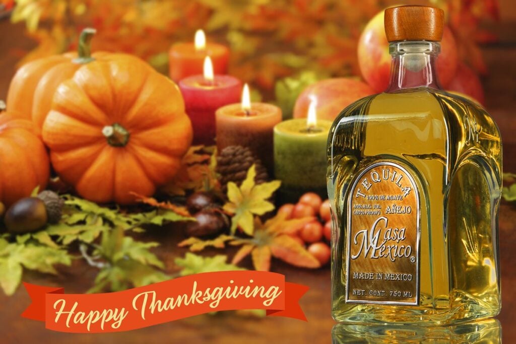 Outdoor Thanksgiving dinner table in Mexico, adorned with traditional Mexican and Thanksgiving decorations, including vibrant colors, Mexican-style tableware, pumpkins, and autumn leaves, set against a scenic Mexican landscape.