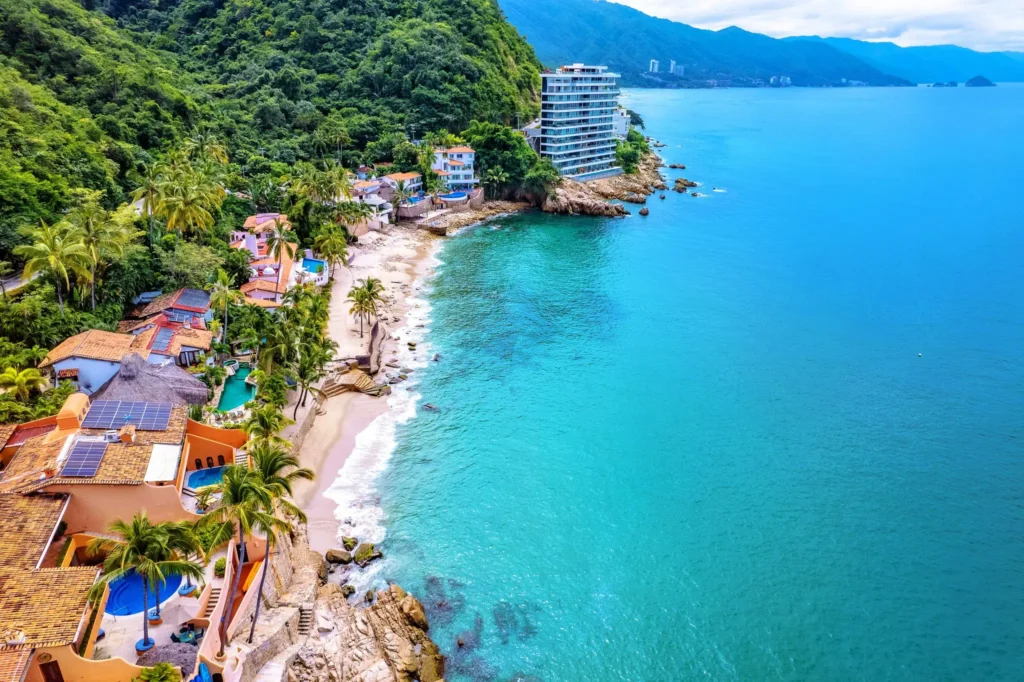 Villa Ventura aerial view of a sandy shoreline, buildings and wooded hills — Puerto Vallarta, Mexico