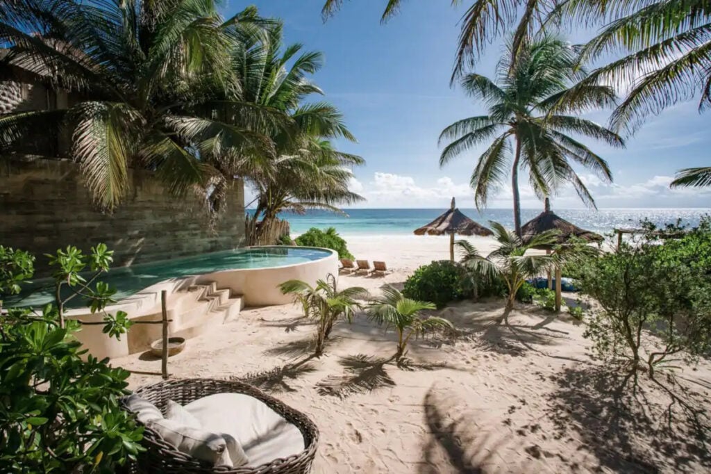 Mahayana Tulum Beach Estate pool garden with palapa, loungers and beach beyond — Tulum, Mexico