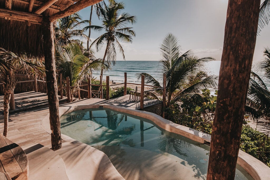 Casa Coco plunge pool and beachfront palms from the covered terrace — Tulum, Mexico