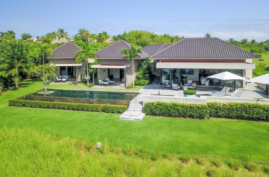 Casa Ensuenos three villa wings beside a long pool, hedges and green lawn — Punta Mita Nayarit, Mexico