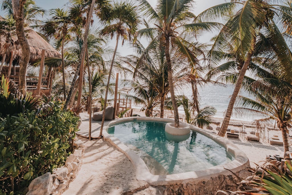 Casa Palma beachfront pool with a round palm island and ocean beyond — Tulum, Mexico