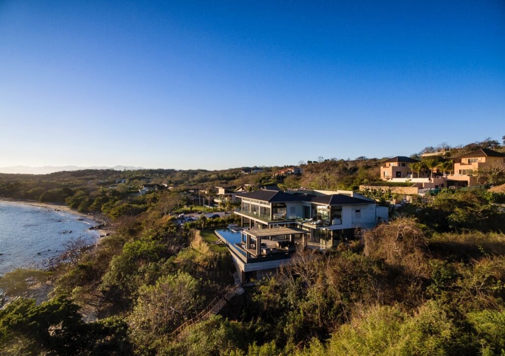 Casa Todo Bien aerial view of the villa on a coastal hillside above the beach — Punta Mita Nayarit, Mexico