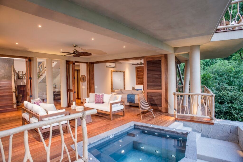 Treehouse covered terrace with cushioned seating beside a square pool — Punta Mita Nayarit, Mexico