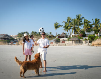 Family with their pet enjoying a beach day in Mexico.