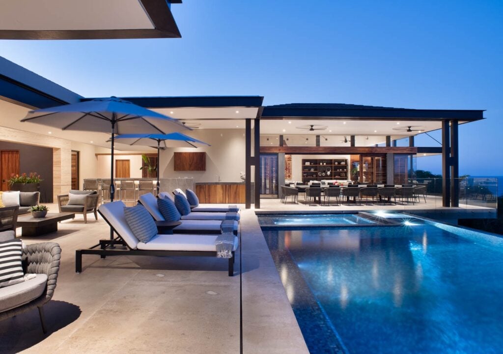 Casa Marias blue umbrellas and striped loungers beside the illuminated pool — Punta Mita Nayarit, Mexico