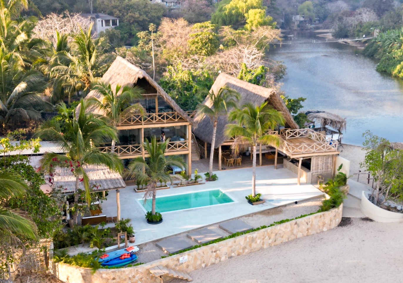 An aerial perspective showcasing the serene Villa Mixto, surrounded by lush jungle, beautiful beachfront, and the river.