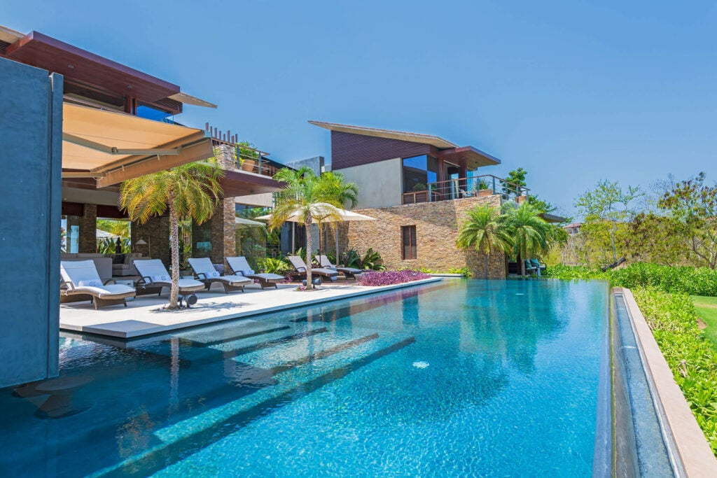 Casa Herradura long pool with a row of loungers beside the villa — Punta Mita Nayarit, Mexico