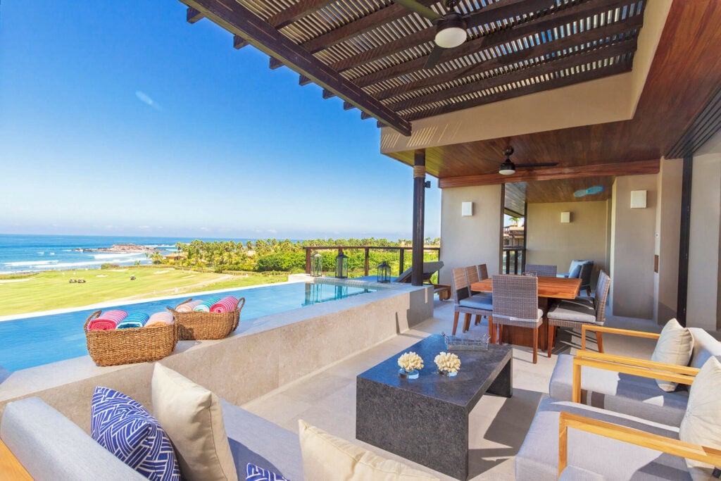 Condo Ara terrace lounge at the pool edge below a timber pergola — Punta Mita Nayarit, Mexico