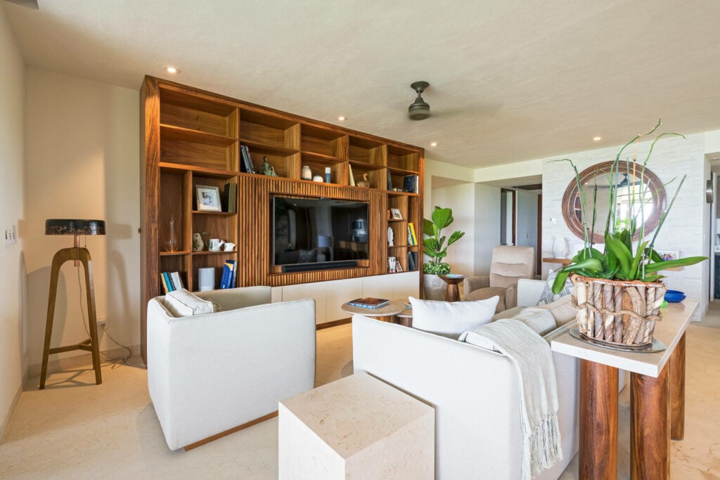 Condo Balboa living room shelving wall with a television facing white sofas — Punta Mita Nayarit, Mexico